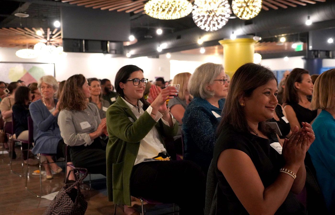 women-clapping-in-seats-at-an-event
